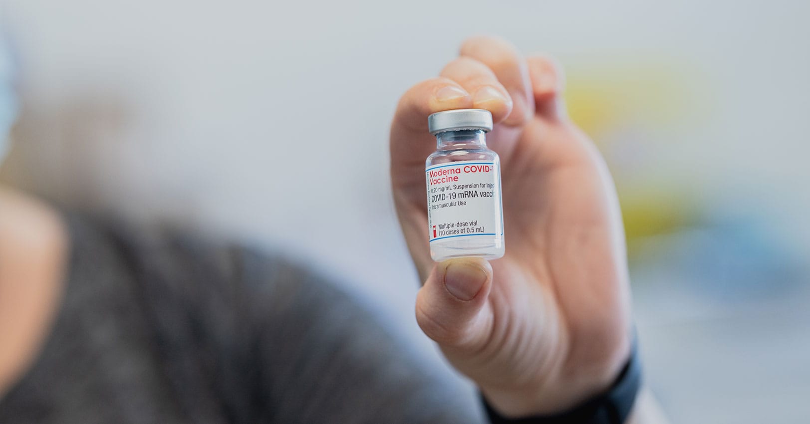 Woman holding vial of Moderna vaccine