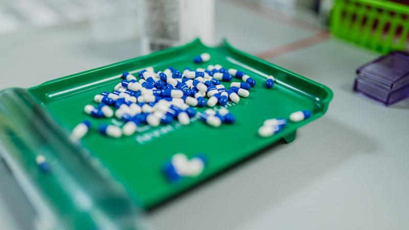 Blue and white pills on a green tray
