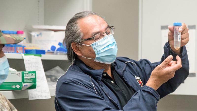 Lab workers examine vial of water
