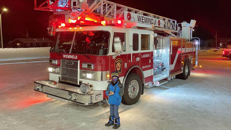 Child stands in front of Wemindji fire truck