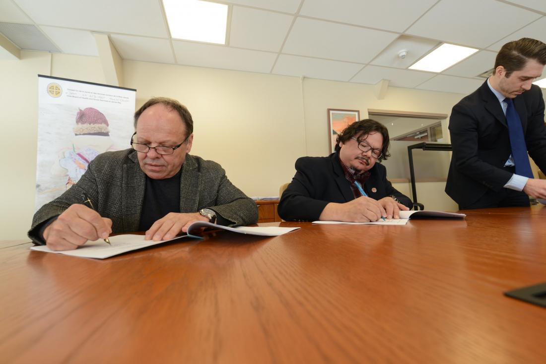Men signing agreement papers