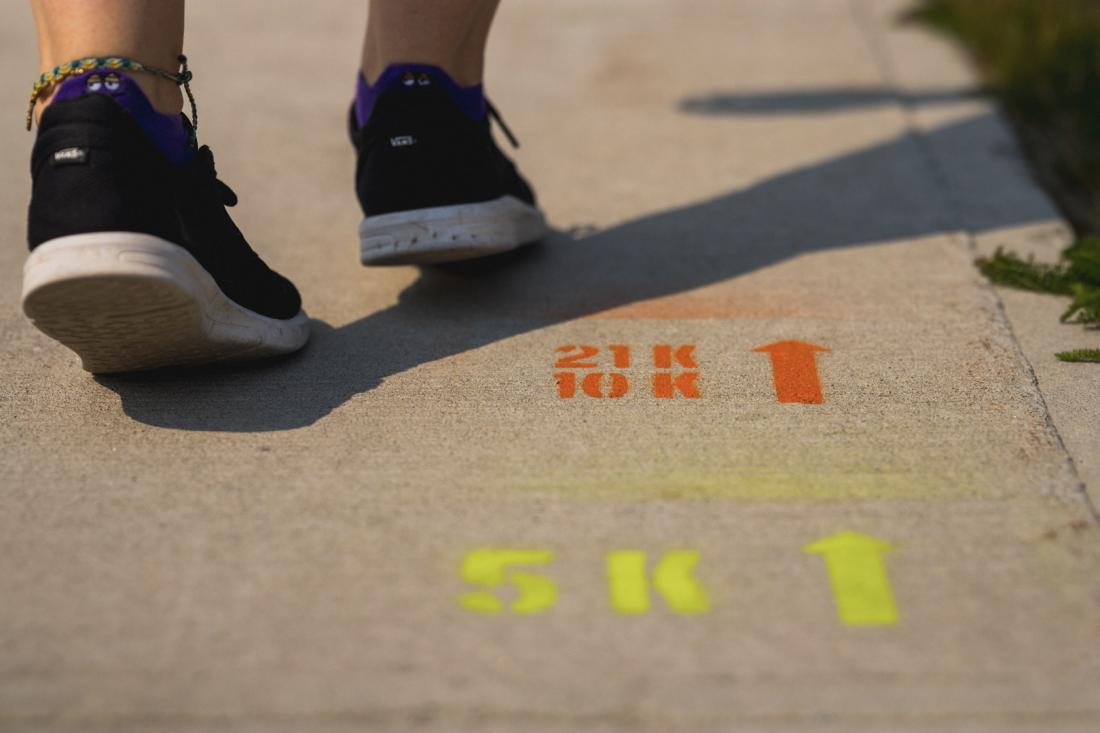 Close up of feet stepping around Chisasibi Run sign on pavement
