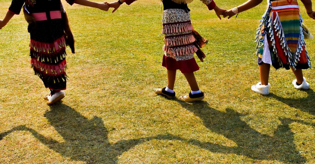 Powwow dancers holding hands