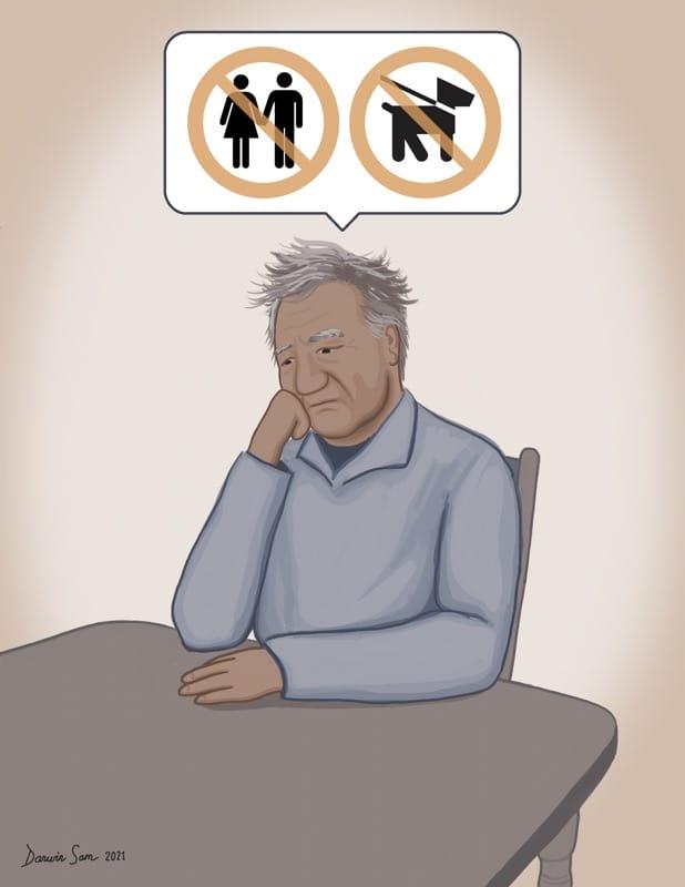 Man sitting at kitchen table with hand on his chin, thinking