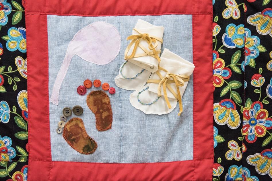 Quilt showing baby footprints and moccasins