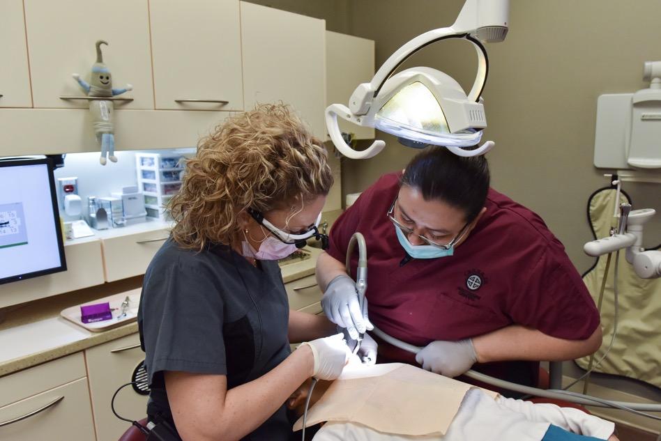 Dentist and dentist assistant treat young patient