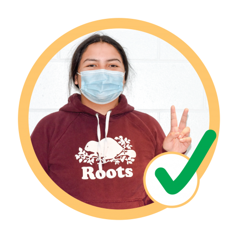 Woman in medical mask doing peace sign check mark